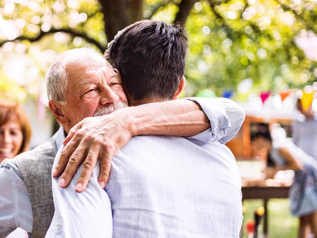 Older man hugging a young man