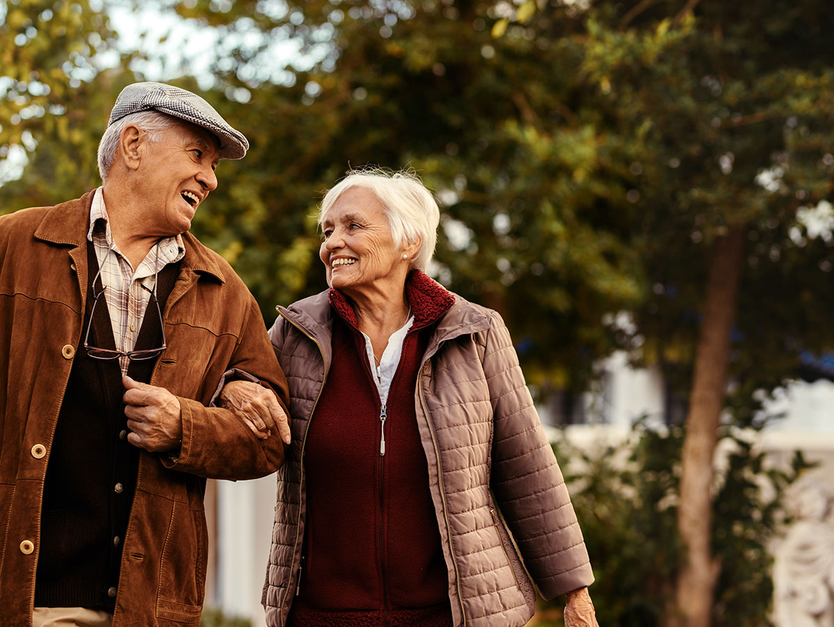 Older couple walking and smiling at one another