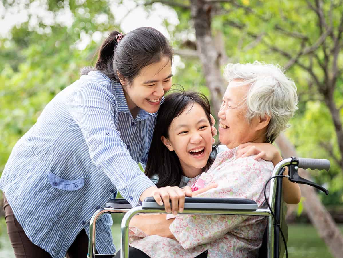 Two young girls hugging older grandma