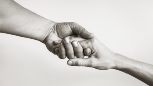 Hands of hospice care patient receiving care and support